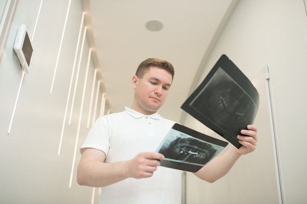 At work. A male doctor scrutinizing xray results and looking serious