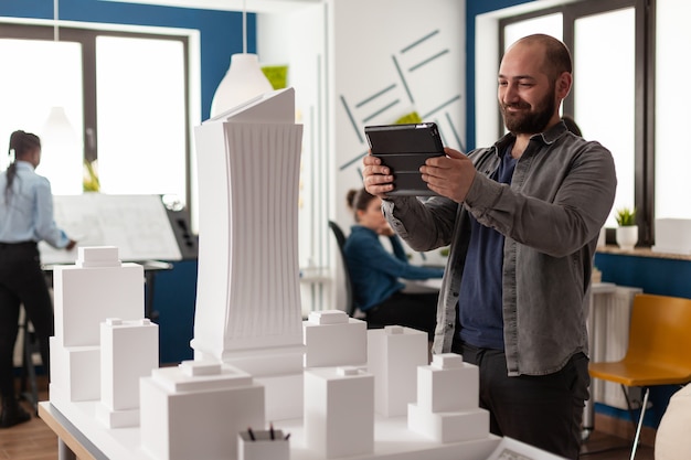 Uomo del manager del lavoro che guarda sul tablet all'ufficio di architettura