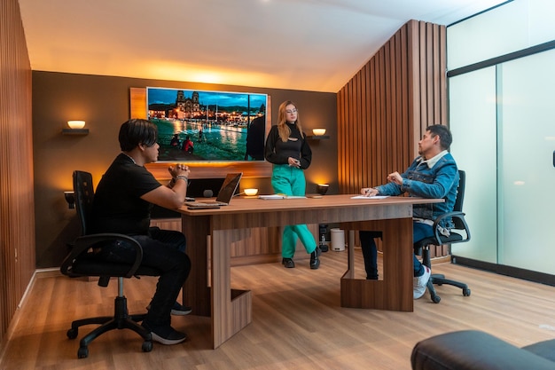 Work meeting in a wooden office with a screen in the background.