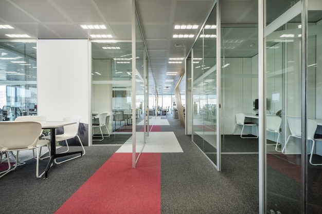 Work offices with glass partitions to separate spaces with carpeted floors and technical ceilings