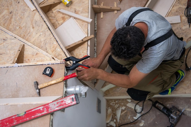 Foto lavori in corso su interni eleganti, falegname professionista che installa scale in legno in un grande e moderno appartamento di lusso su due livelli