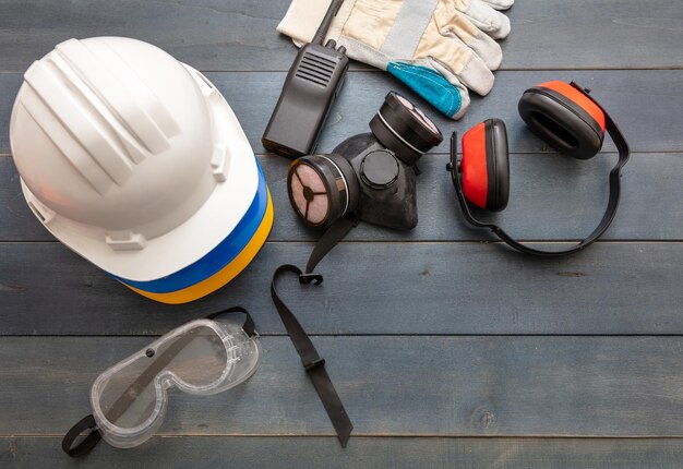 Work safety protection equipment flat lay on wooden\
background