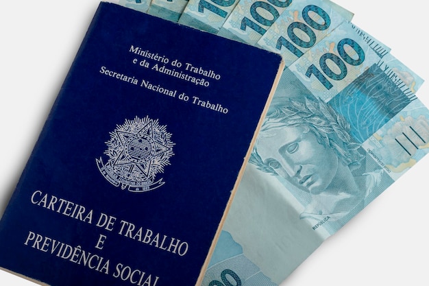 Carta di lavoro e di previdenza sociale con banconote brasiliane isolate su sfondo bianco