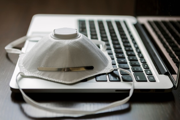 Work space at home with a computer and a face mask