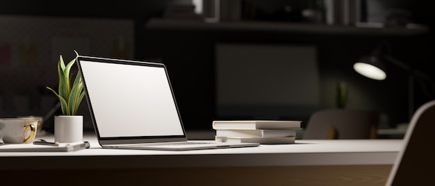 work space at late night open laptop under the light in dark room decor with office supplies