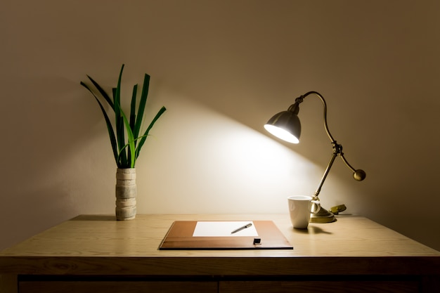 Foto lavoro tabel con planner, penna, tazza di caffè e lampada