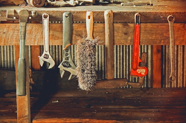 Foto strumenti da lavoro appesi al legno in officina