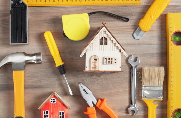 Foto strumenti di lavoro con un modello di casa in legno.