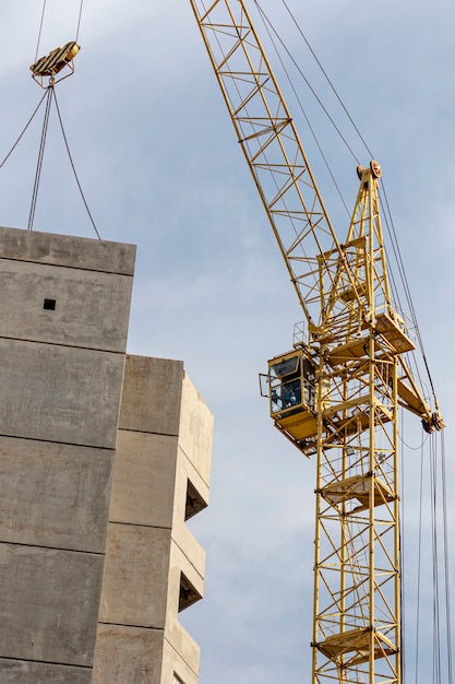 the work of a tower crane during the construction of a panel house made of reinforced concrete