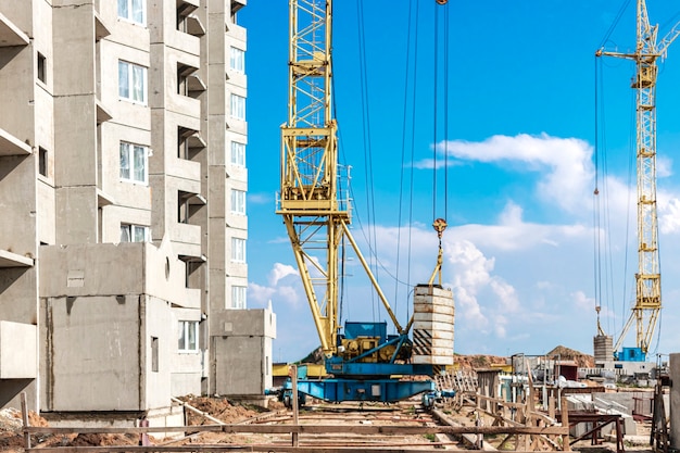 Il lavoro di una gru a torre durante la costruzione di una casa a pannelli in cemento armato