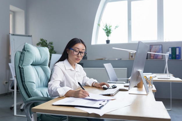 Work with documents portrait of a young beautiful business woman asian accountant works with