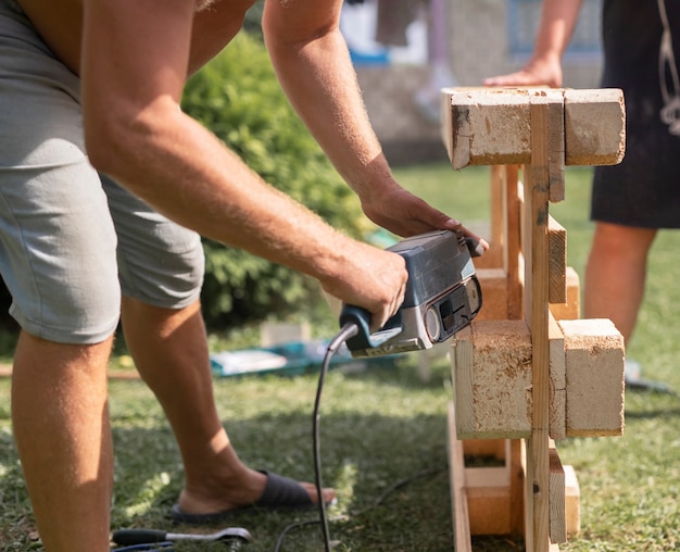 屋外の自然の中で木製の家具を作る木のコンセプトで作業する