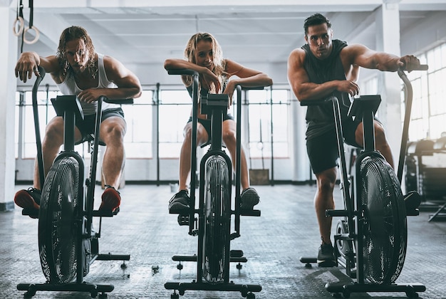 Work till you just cant work anymore Shot of three people working out on elliptical machines