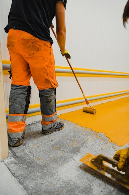 Worker applying epoxy and polyurethane flooring system