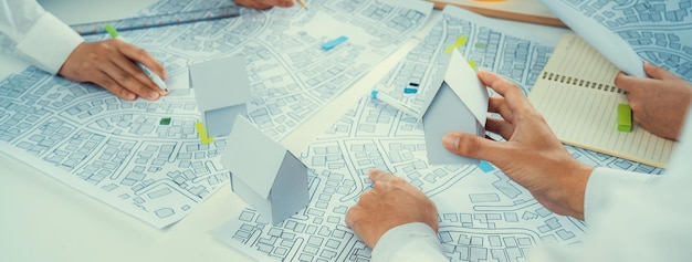 Worker architect and engineer work on real estate construction project oratory planning with cartography and cadastral map of urban town area to guide to construction developer business plan of city
