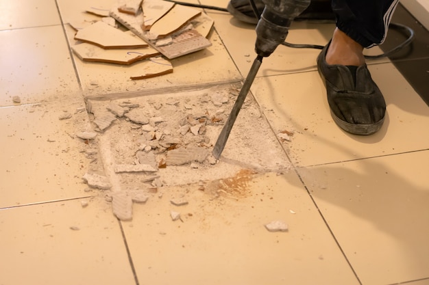 Worker are removing broken tiles for repair.