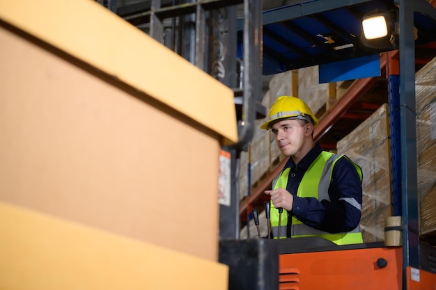 Worker in auto parts warehouse use a forklift to work to bring the box of auto parts