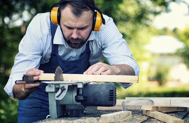 Worker beard man with circular saw