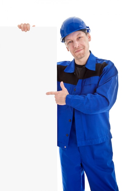 Il lavoratore in uniforme blu che punta sul cartellone bianco segno