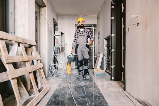 A worker in building in construction process carry toolbox and getting ready for work