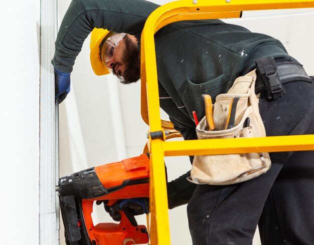 Worker builds a plasterboard wall