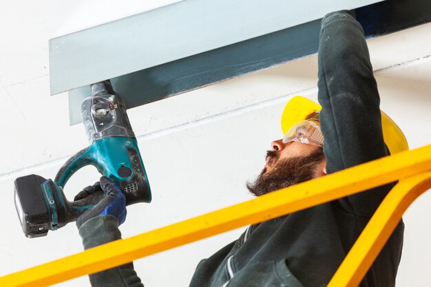 Worker builds a plasterboard wall