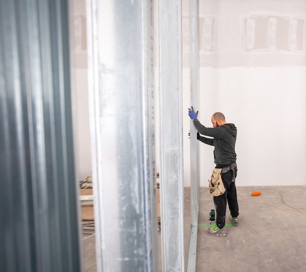 Worker builds a plasterboard wall