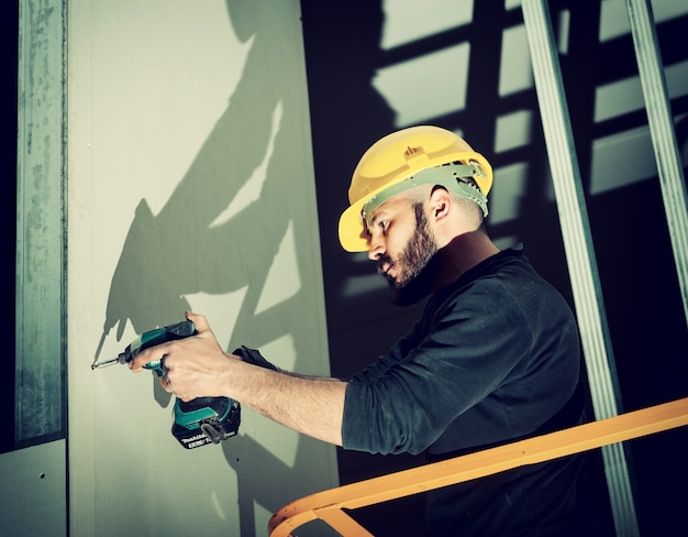 Photo worker builds a plasterboard wall