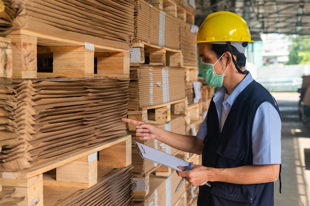 Lavoratore che controlla la materia prima in negozio per l'industria della fabbrica, ingegnere della sicurezza