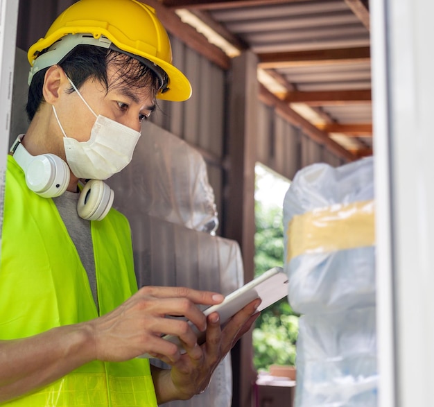 在庫を確認する作業員 タブレットを使用して飲料水製品工場のオンライン在庫を更新する