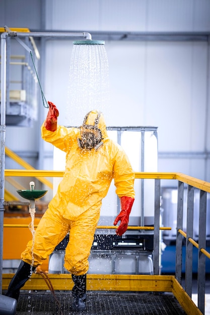 Работник химического завода принимает душ, чтобы смыть кислоту после аварии