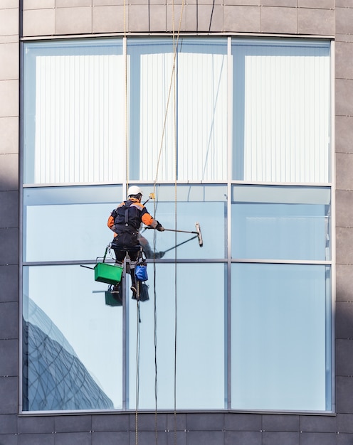 Worker cleaning windows of and office high-rise building 