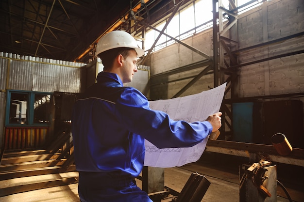 Worker in a construction helmet with a drawing