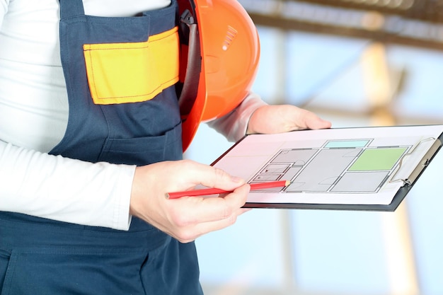 worker in a construction site holds a project of a flat