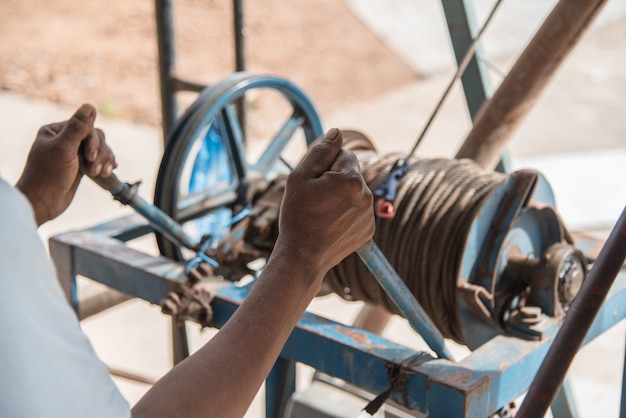 Photo worker control steel rope in construction site