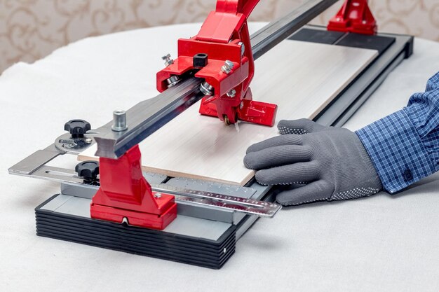 A worker cuts facing tiles with a tile cutter