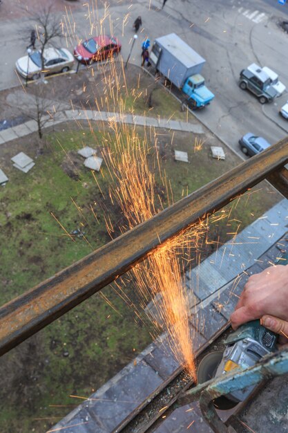 A worker cuts metal with a grinder