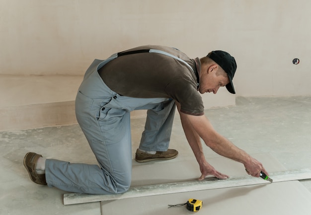 Photo worker cuts a piece of drywall