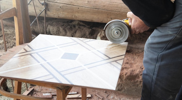 Worker cutting a ceramic tile with a grinder