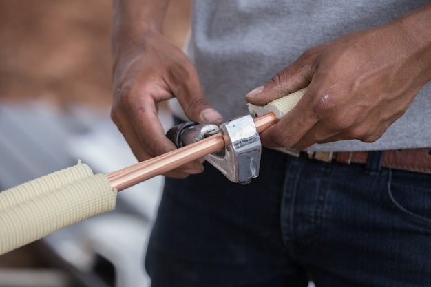 worker cutting copper pipe of air conditioner