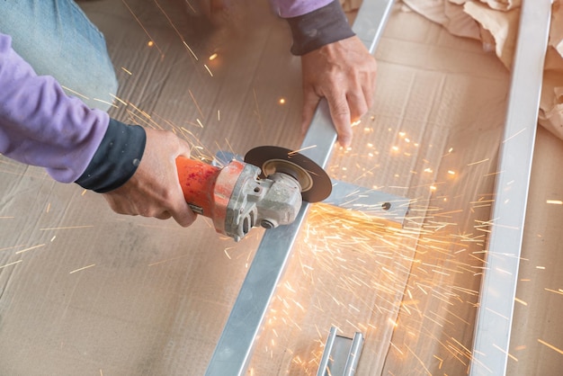 Foto lavoratore che taglia il metallo con una macina elettrica in un cantiere