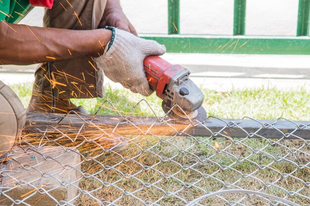 Worker cutting metal with grinder. Sparks while grinding iron