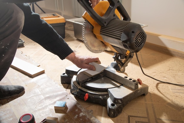 Photo worker cutting part of furniture with cutting machine