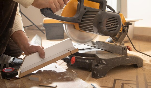 Worker cutting part of furniture with cutting machine