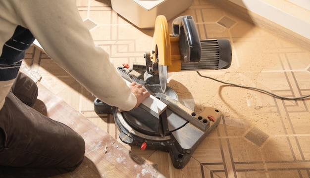 Photo worker cutting part of furniture with cutting machine