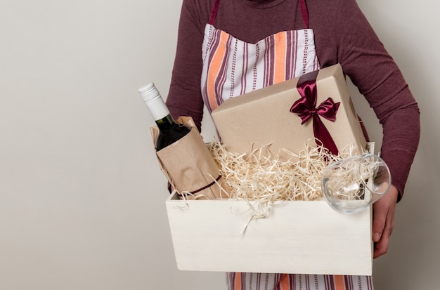 Worker of Delivery Service Packing Wine Bottle and Gifts to box with straw for Customer.