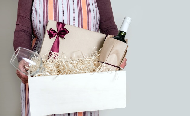 Worker of Delivery Service Packing Wine Bottle and Gifts to box with straw for Customer.