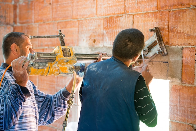 Worker demolish wall in house 