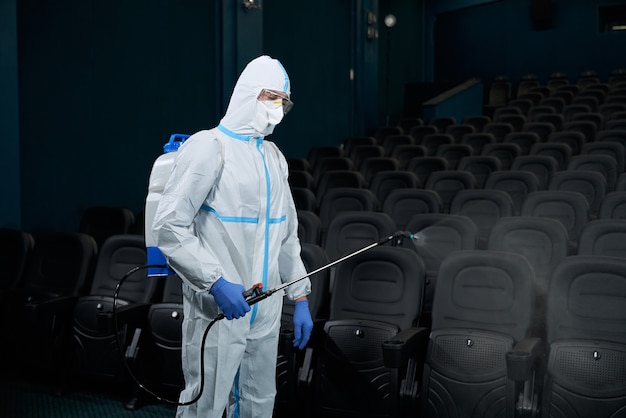 Worker disinfect cinema hall against coronavirus.