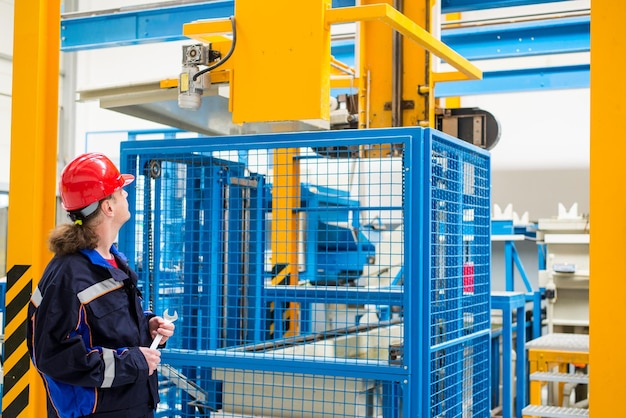 Worker in a factory looking up in machines in the background